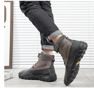 Vue détaillée de bottines de travail pour hommes en cuir noir et gris portées par un modèle.