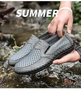 Close-up of grey mesh summer shoes with crocodile texture held over a natural stream