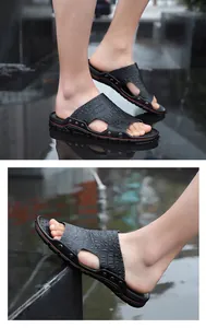 Close-up view of men's casual black slip-on sandals with croc pattern and metal rivets.