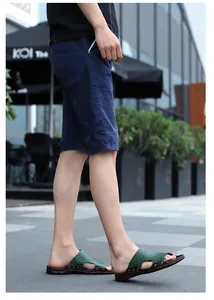 Side view of stylish men's casual green crocodile pattern slip-on sandals in a street
