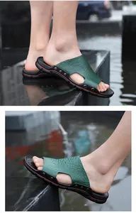 Detailed side view of green crocodile texture men's casual summer slippers.