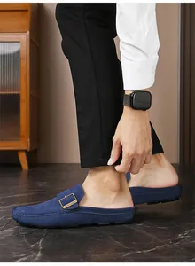 Dettaglio laterale di mocassini sabot in camoscio blu da uomo con fibbia dorata