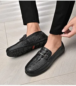 Primer plano de mocasines de hombre en cuero con relieve de cocodrilo negro y hebilla