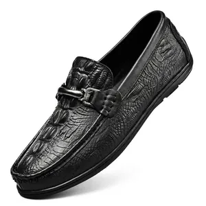 Elegantes mocasines de cuero negro con relieve de cocodrilo y una hebilla metálica.