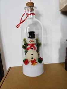 Detailed view of a miniature snowman figurine inside a glass message bottle