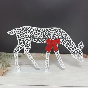White hollow metal Christmas deer ornament with red bow on wood