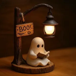 Detailed shot of a cute ghost figurine reading a book under a glowing Halloween lantern