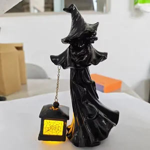Detailopname van een zwarte heks van hars met een lichtgevende LED-spinnenweblantaarn.