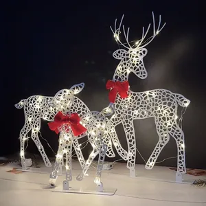 Set of three white metal Christmas reindeer with warm LED lights and red bows