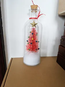 Detailed view of a miniature red Christmas tree with a star inside a glass bottle
