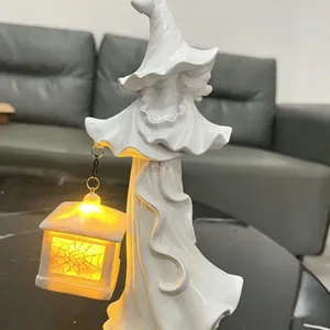 Close-up van de gloeiende LED-lantaarn op het witte hars heksenbeeldje voor Halloween