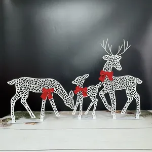 Close-up view of white metal Christmas reindeer family ornaments with festive red bows