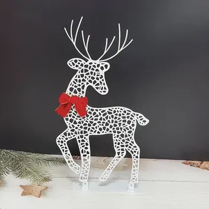 Detailed macro view of white hollow iron reindeer featuring a red bow Christmas decoration
