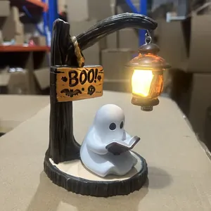 Detailed view of Halloween resin ghost figurine reading a book under a warm glowing lamp
