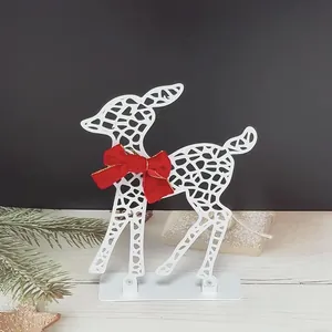 Detailed view of white hollow metal Christmas reindeer ornament featuring a red velvet bow