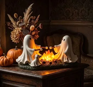 Detail of cute resin ghosts roasting marshmallows over a glowing campfire ornament