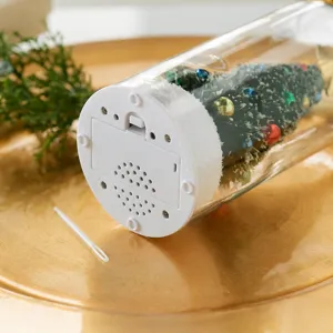 Detail view of the bottom base of the Christmas tree bottle with battery compartment.