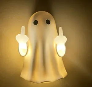 Detail of Halloween ghost wall light showing funny middle finger gesture and warm glow