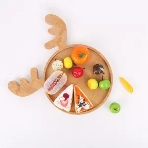 Festive reindeer shaped wooden serving tray decorated with artificial cakes and fruits