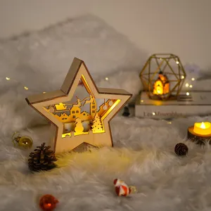 Detailansicht eines leuchtenden Holzstern-Weihnachtsschmucks mit festlich geschnitzter Szenerie