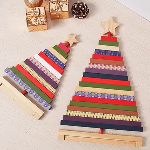 Due dimensioni di decorazioni per alberi di Natale rotanti in legno su una scrivania