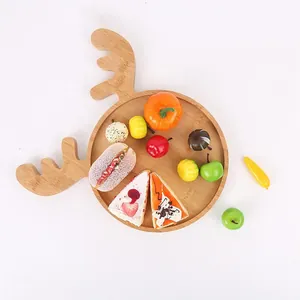 Reindeer-shaped wooden serving tray with festive decorative artificial food props