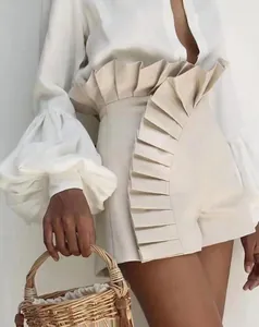 Detailed view of women's cream high waist shorts featuring elegant ruffle and pleat design