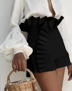 Detailed view of high-waisted black shorts featuring large pleated ruffles.