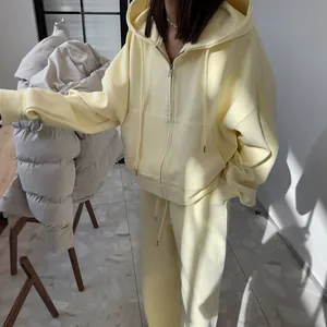 Detailweergave van oversized crèmegeel sweatshirt met rits en bijpassende joggingbroek