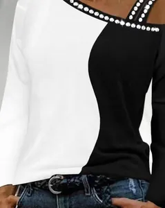Primo piano di un top bicolore bianco e nero con strass eleganti sulla scollatura