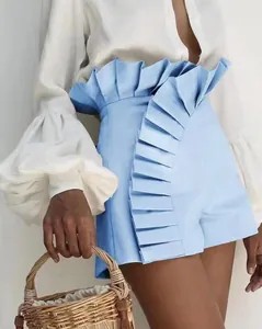 Detail shot of light blue high-waisted shorts featuring elegant pleated ruffles