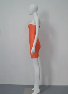 Profil latéral d'une robe mini bandage moulante orange vif sans bretelles sur mannequin.