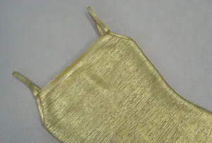 Détail du tissu en feuille d'or chatoyant sur une robe bandage sexy pour la fête