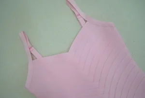 Gros plan d'une robe bandage rose avec décolleté en V et détail à double bride