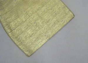 Gros plan haute résolution du tissu bandage métallisé doré pour robe de soirée chic