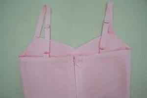 Détail d'une robe bandage rose avec bretelles réglables et fermeture éclair arrière