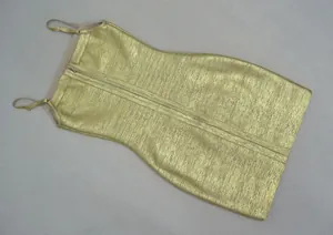 Détail d'une robe moulante bandage en or métallisé avec de fines bretelles sexy