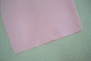 Gros plan d'une robe bandage rose montrant le tissu côtelé texturé et l'ourlet.
