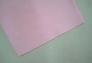 Gros-plan sur la texture détaillée du tissu rose d'une robe bandage de qualité