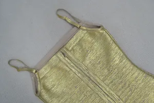 Détail d'une robe bandage dorée avec fines bretelles réglables et fermeture éclair