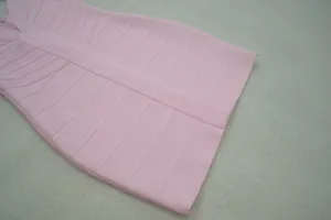 Κοντινό πλάνο υφάσματος ροζ φορέματος bandage με ανάγλυφες ρίγες και ραφές