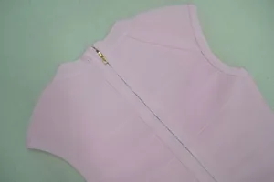 Vue détaillée de la fermeture éclair et de la texture bandage sur un top rose