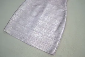 Gros plan d'une robe bandage rose métallisée montrant sa texture scintillante.