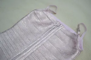 Vue détaillée de la texture dorée scintillante sur une robe bandage rose à bretelles