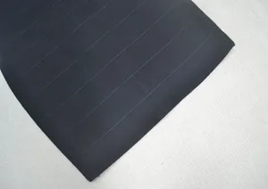 Gros plan sur le tissu de la robe bandage noire montrant le détail côtelé texturé