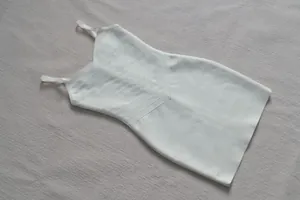 Vue détaillée d'une robe bandage blanche moulante avec décolleté en V et texture