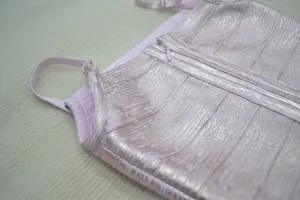 Gros plan d'une robe bandage rose métallisée avec fines bretelles et fermeture