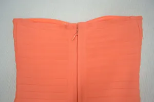 Gros plan sur la fermeture éclair et la texture du tissu de cette mini-robe bandage orange chic
