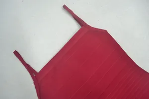 Gros plan sur les bretelles et la texture côtelée d'une robe bandage couleur bordeaux