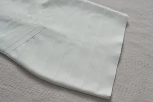 Vue détaillée de la texture côtelée haut de gamme d'une robe bandage moulante blanche